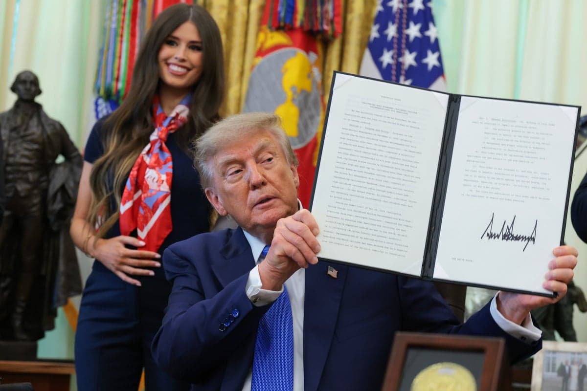 ‘Bobble head’ woman behind Trump in Oval Office explains why she kept holding her stomach